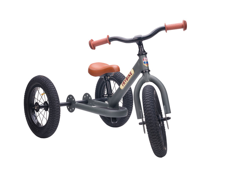 Children's balance bike with tricycle attachment on a white background
