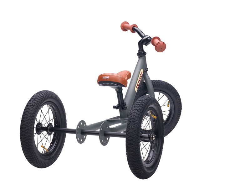 Children's balance bike with three wheels on a white background