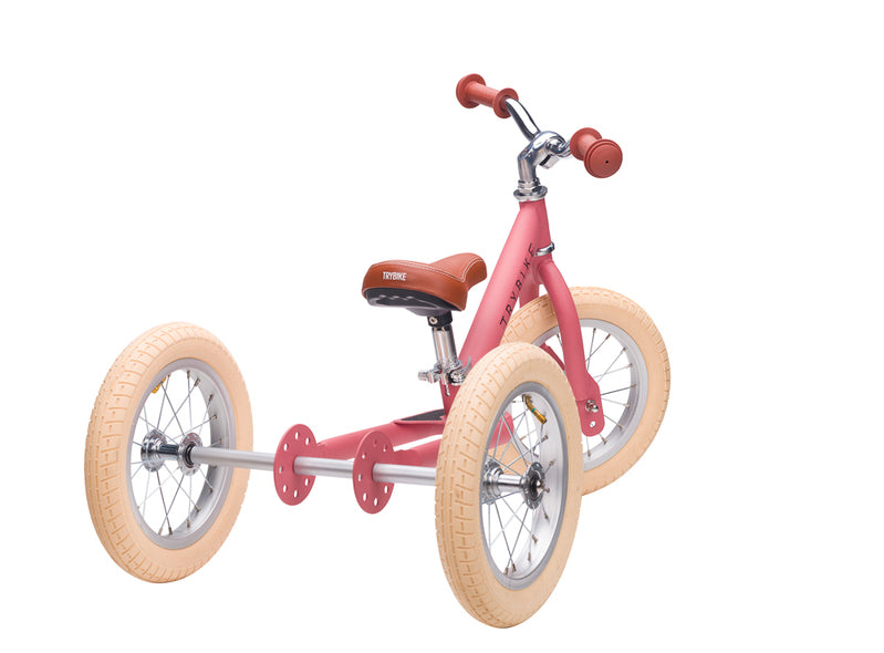 Pink tricycle with beige tires on a white background