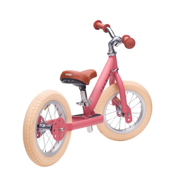 Pink balance bike with white wheels on a white background