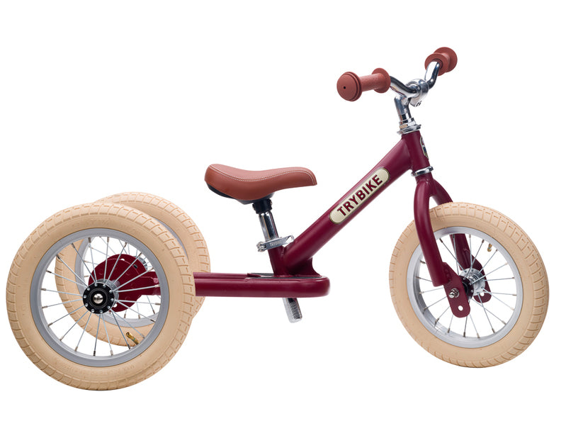 Red balance bike with beige tyres on a white background
