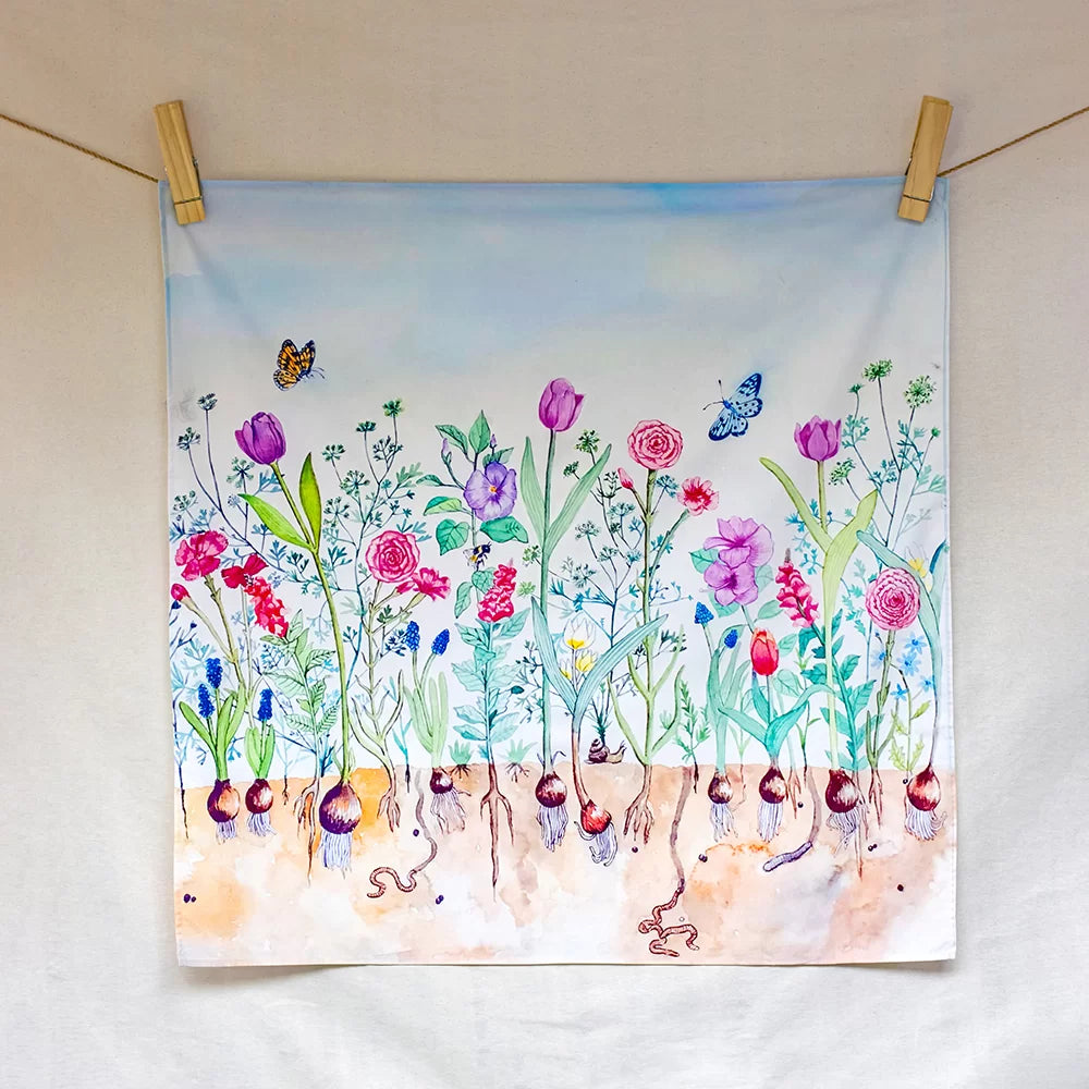 Colorful floral painting hanging on a line with wooden clips.