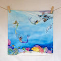 Colorful illustration of mermaids and dolphins underwater with coral on a white background.