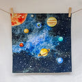 Painting of planets on a starry background hanging on a line with clothespins.