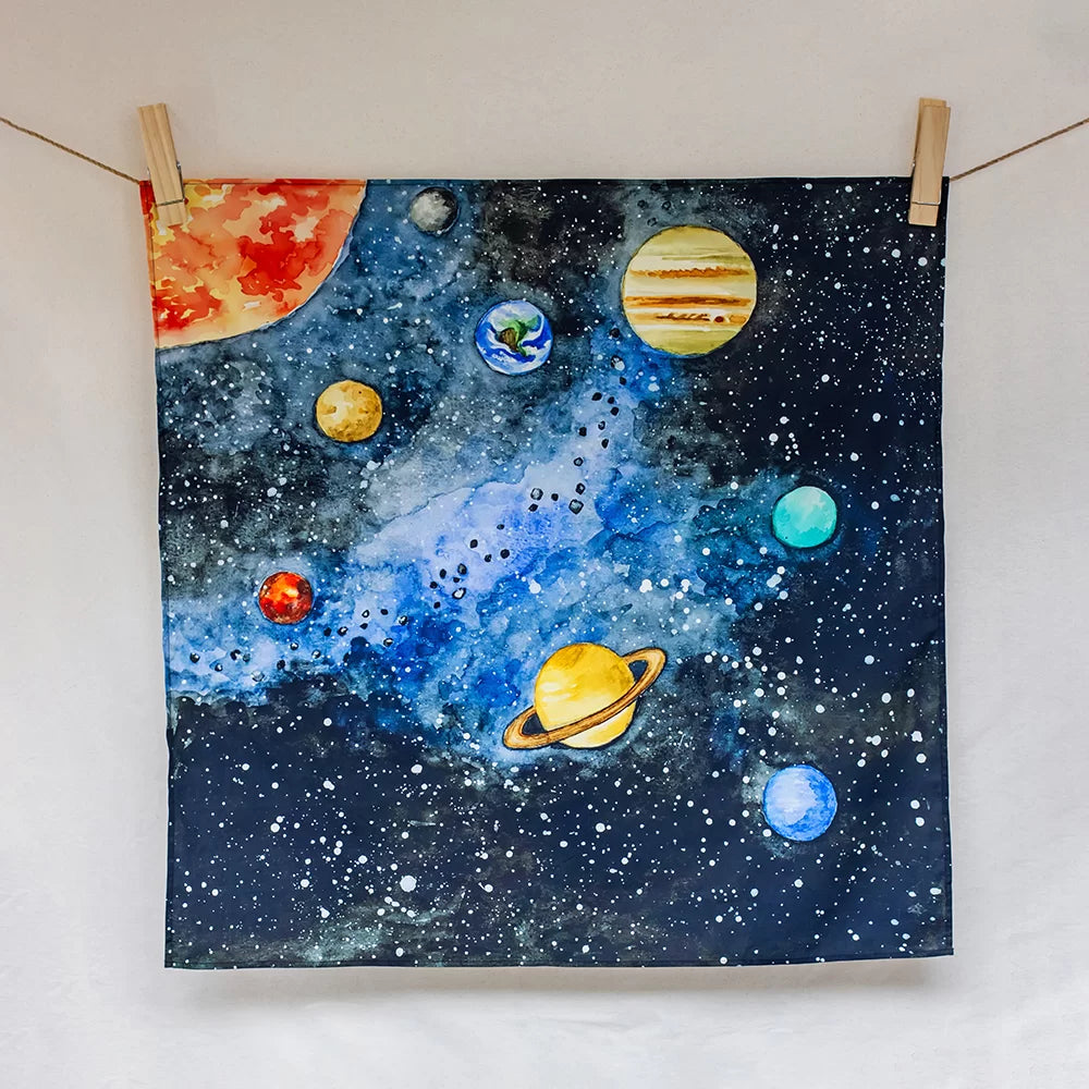 Painting of planets on a starry background hanging on a line with clothespins.