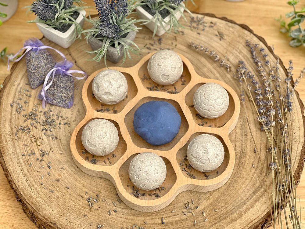 Wooden mold with six stones on a wooden surface with lavender and plants.